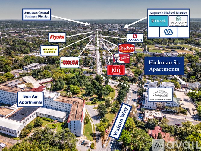 An aerial view of a city with a road running through it and buildings on either side.