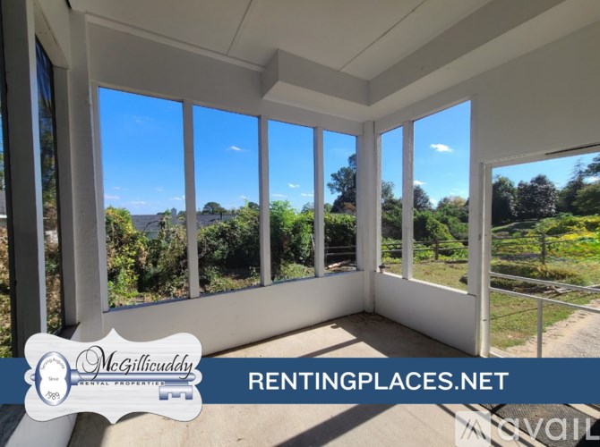 A room with a view of a garden through large windows.