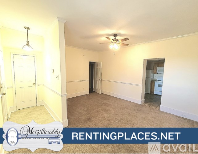 A room with a ceiling fan and a light fixture, with a door on the left and a window on the right.