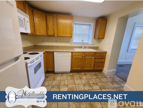 A kitchen with wooden cabinets and a tiled floor.