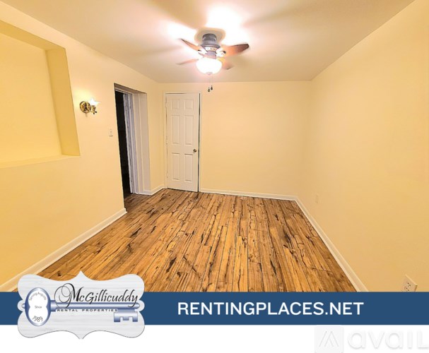 A room with wooden flooring and a ceiling fan.