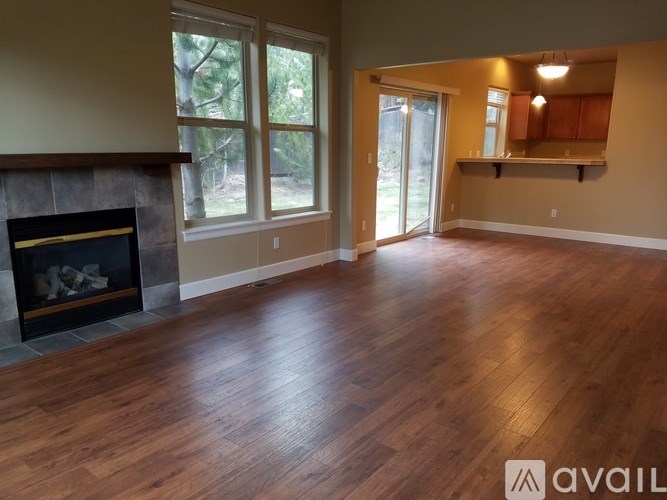 A room with a fireplace and wooden floors.