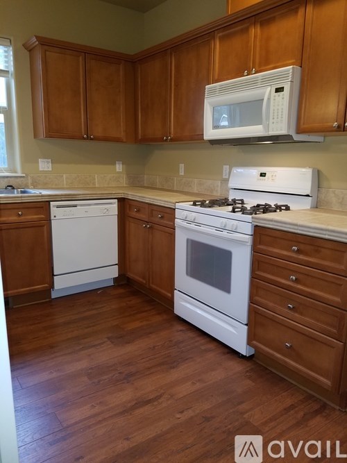 A kitchen with wooden cabinets and white appliances.