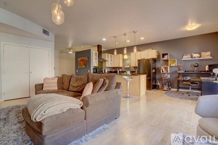 A living room with a couch, chairs, and a rug.