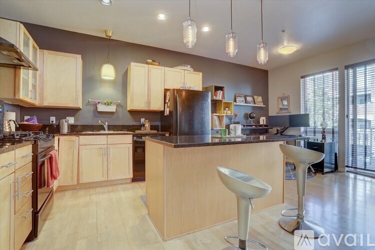 A kitchen with wooden cabinets and a black countertop.