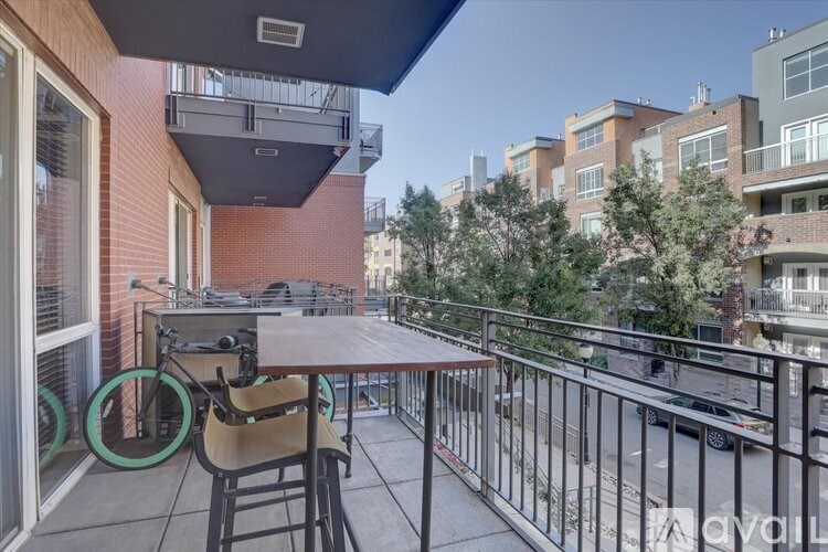 A balcony with a table and chairs overlooking a street.