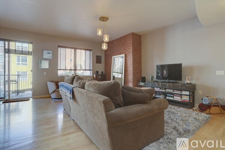A living room with a brown couch and a television.