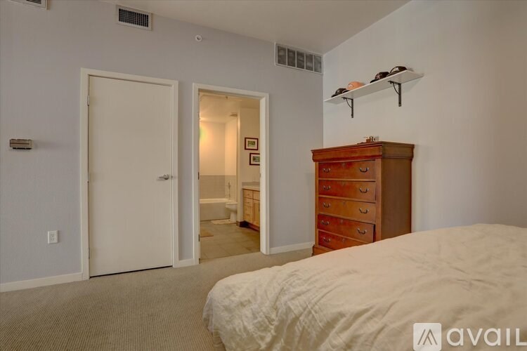A bedroom with a bed, dresser, and a small closet.