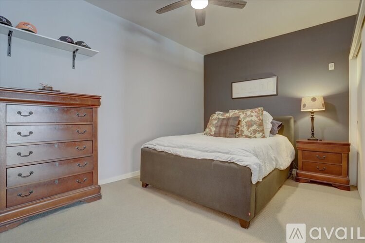 A bedroom with a bed, dresser, and nightstand.