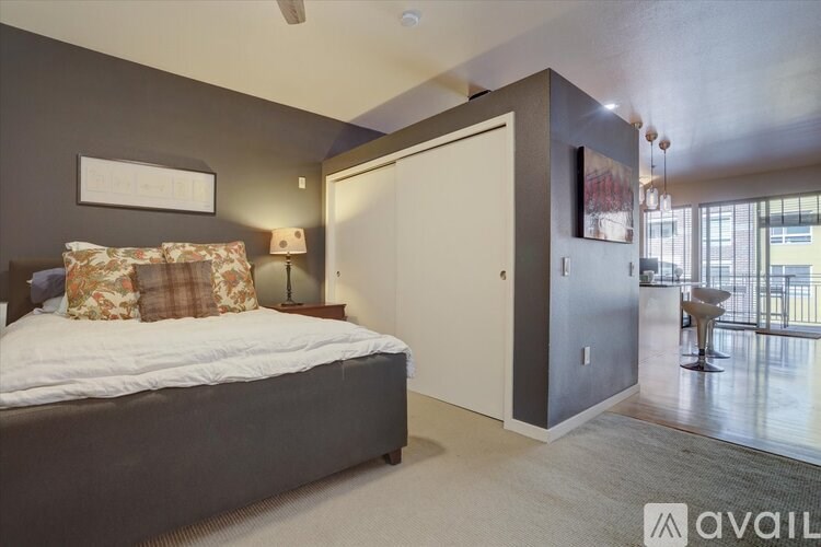 A bedroom with a bed, a lamp, and a chair.