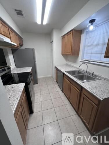 A kitchen with a refrigerator, sink, and cabinets.