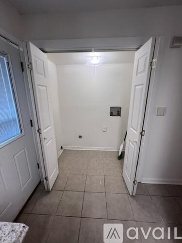 A small, empty room with a tiled floor and white walls.