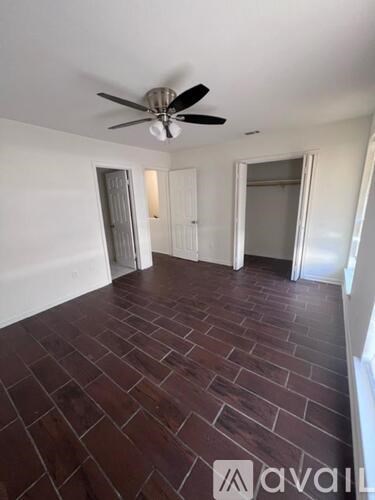 A room with a ceiling fan and wooden flooring.