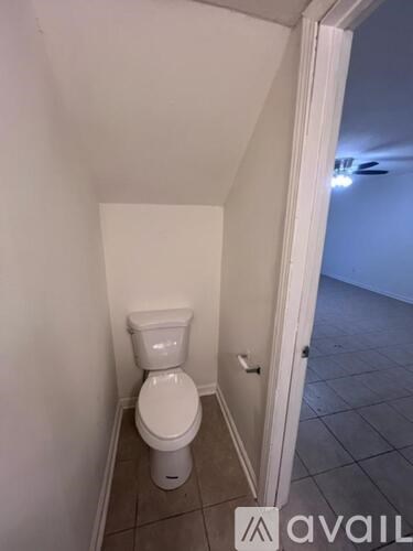 A white toilet in a small bathroom with a white door.
