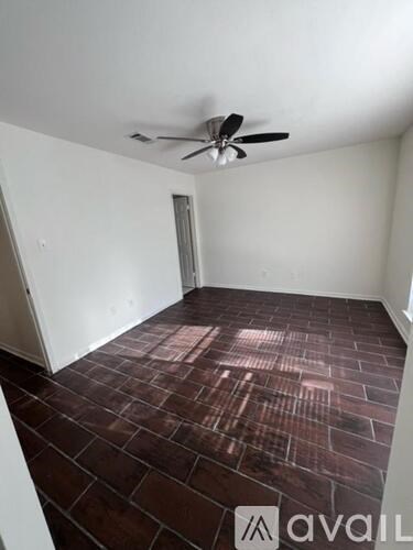 A room with a ceiling fan and tiled flooring.