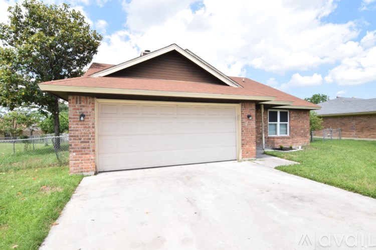 A house with a garage door and a brick chimney.