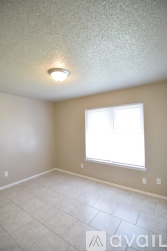 A room with a window and a light on the ceiling.