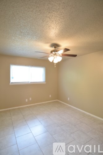 A room with a ceiling fan and a window.