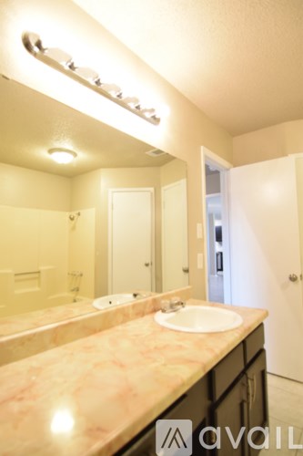 A bathroom with a marble counter top and a large mirror.