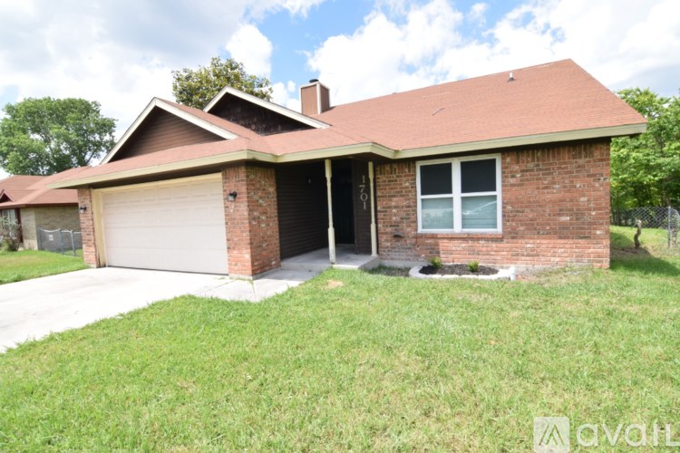 A house with a garage and a brick exterior.