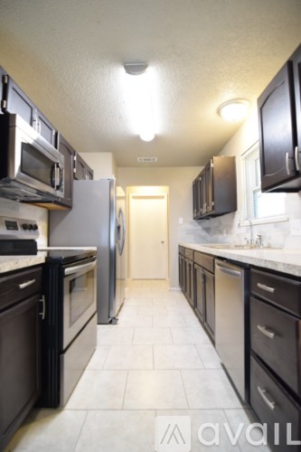 A kitchen with black cabinets and a white refrigerator.