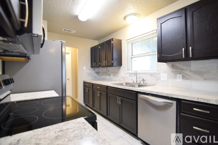 A kitchen with black cabinets and a stove top oven.