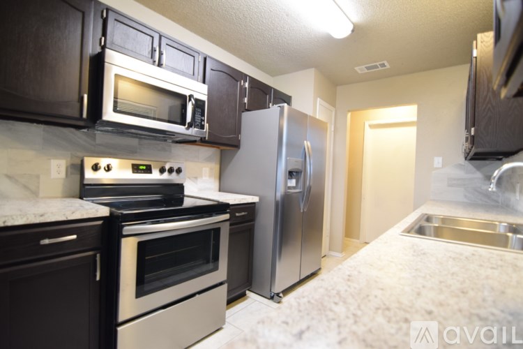 A kitchen with a stove, oven, refrigerator, and microwave.