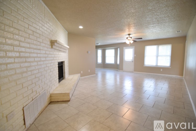 A spacious living room with a fireplace and tiled flooring.