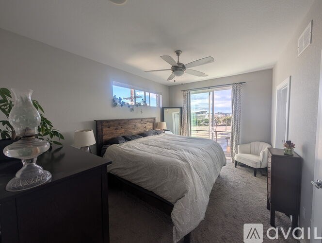 A bedroom with a large bed and a ceiling fan.