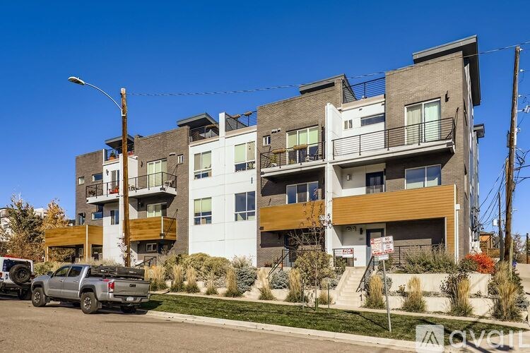 A modern multi-story building with a balcony on the top floor.