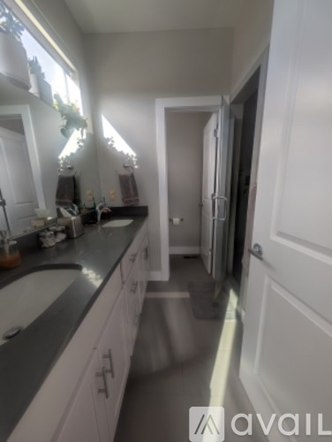 A kitchen with white cabinets and a black counter top.