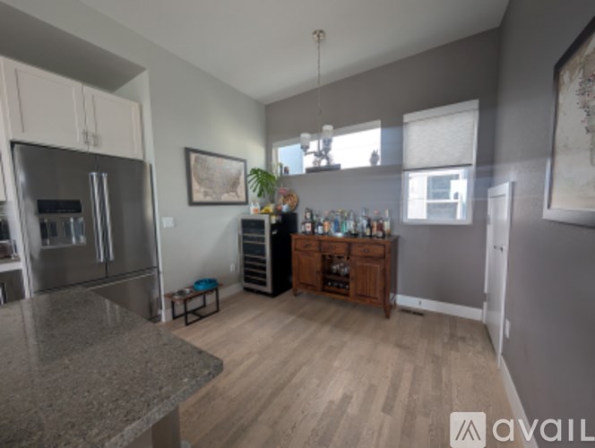 A kitchen with a refrigerator, a counter, and a cabinet.