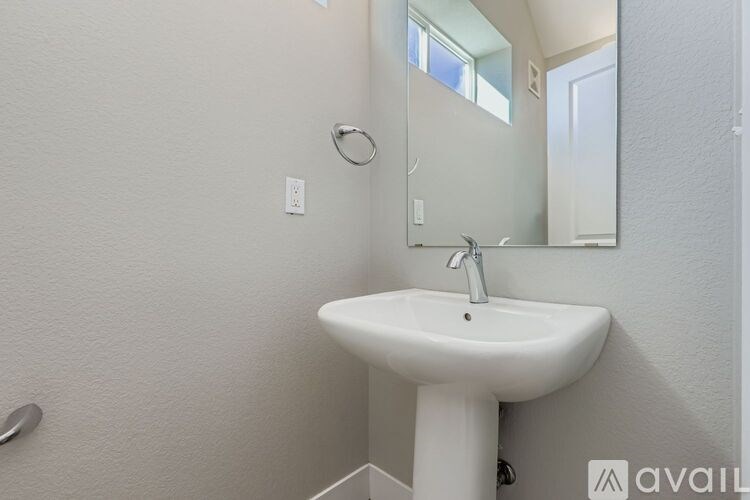 A living room with a television, a couch, a coffee table, and a ceiling fan.