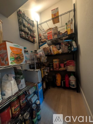 A small pantry with a lot of food and drinks on the shelves.