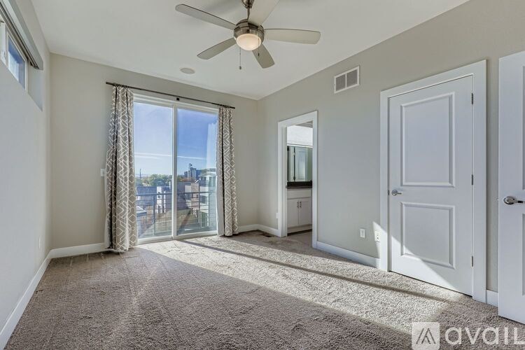 A room with a white wall and a wooden floor with a pile of bags and boxes.