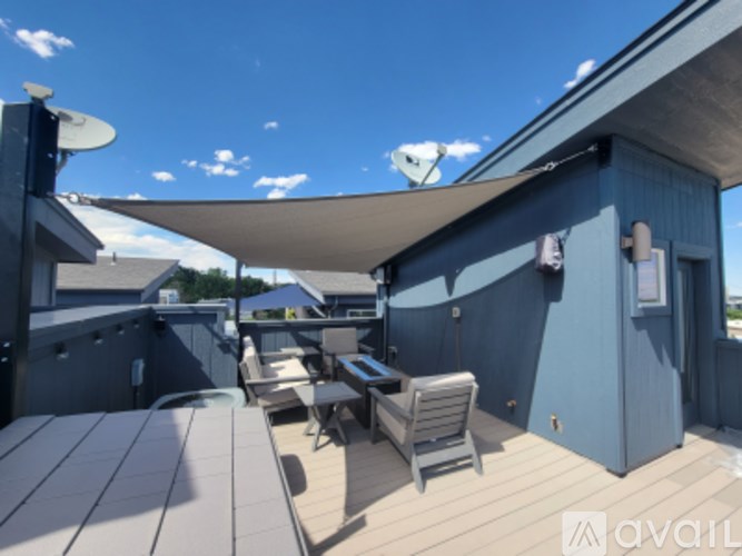 A patio with a table and chairs under a shade sail.