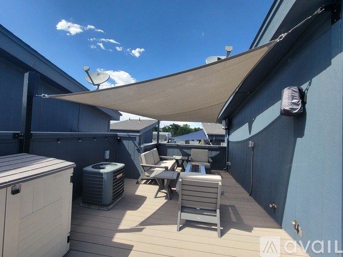 A sunny day on a wooden deck with a white umbrella providing shade.