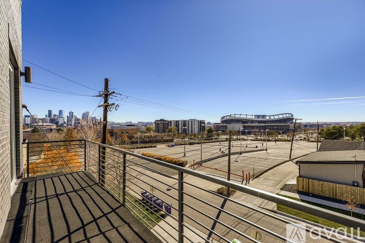 A view from a balcony overlooking a parking lot and buildings.