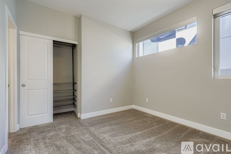 A room with a carpeted floor and a window.