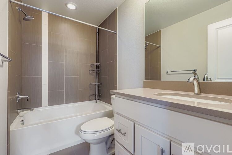 A bathroom with a white toilet, a bathtub, and a sink.