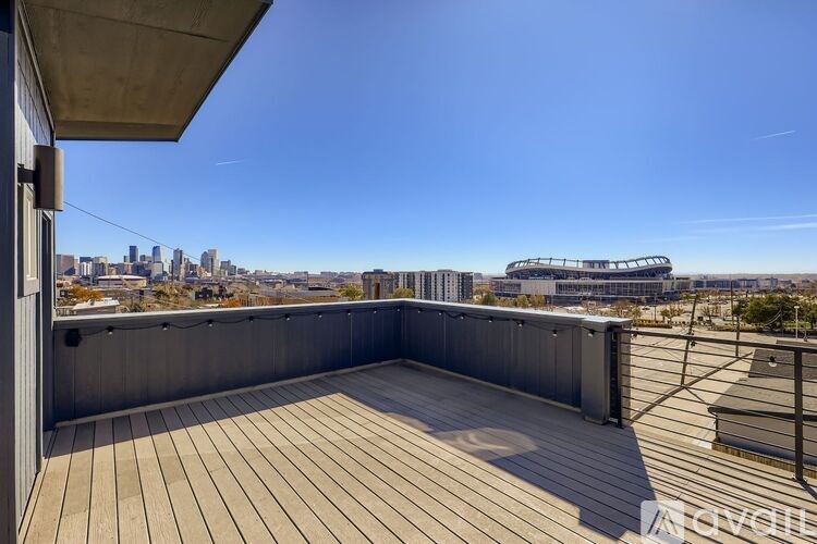 A rooftop deck with a wooden floor and a city skyline in the background.