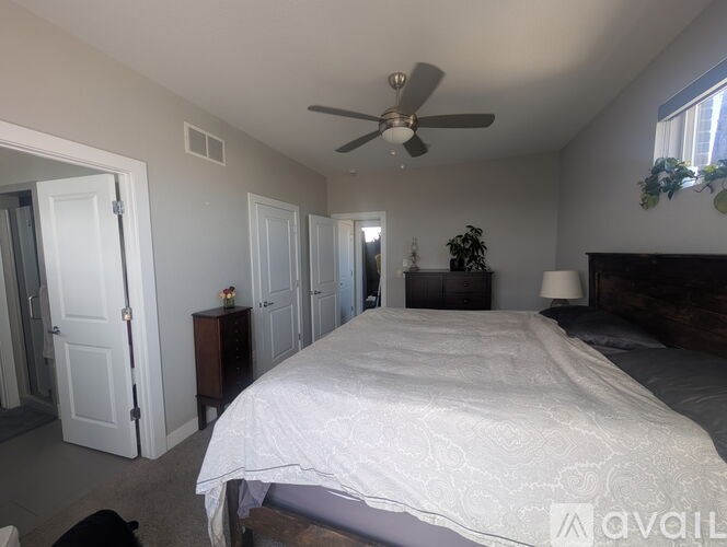 A bedroom with a large bed and a ceiling fan.
