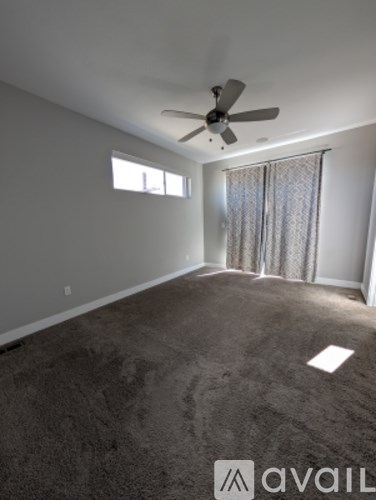 A room with a ceiling fan and carpeted floor.