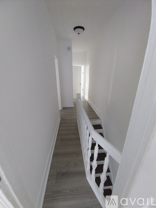 A long hallway with a white railing on the right side.