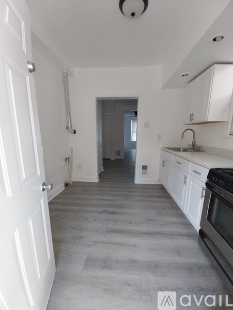 A kitchen with white cabinets and a black stove top oven.