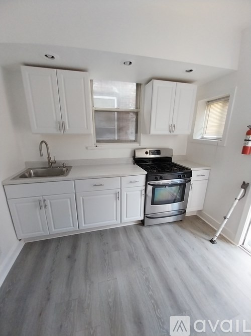 A kitchen with white cabinets and a stove top oven.