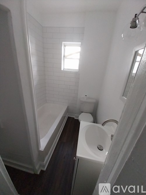 A small white bathroom with a toilet, sink and bathtub.