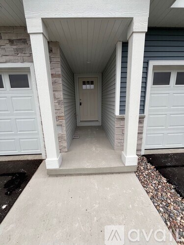 A white door is in the middle of a concrete walkway.