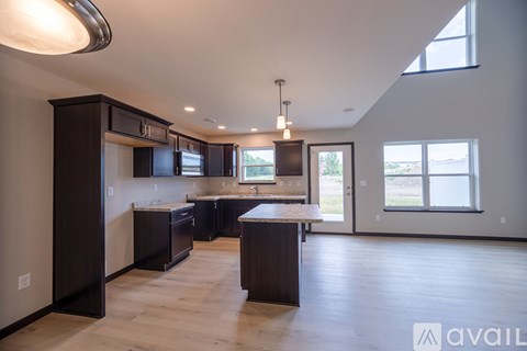 A spacious kitchen with dark wood cabinets and a large island.