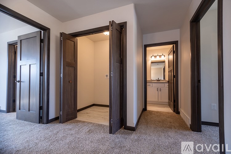 A carpeted room with a doorway leading to another room.